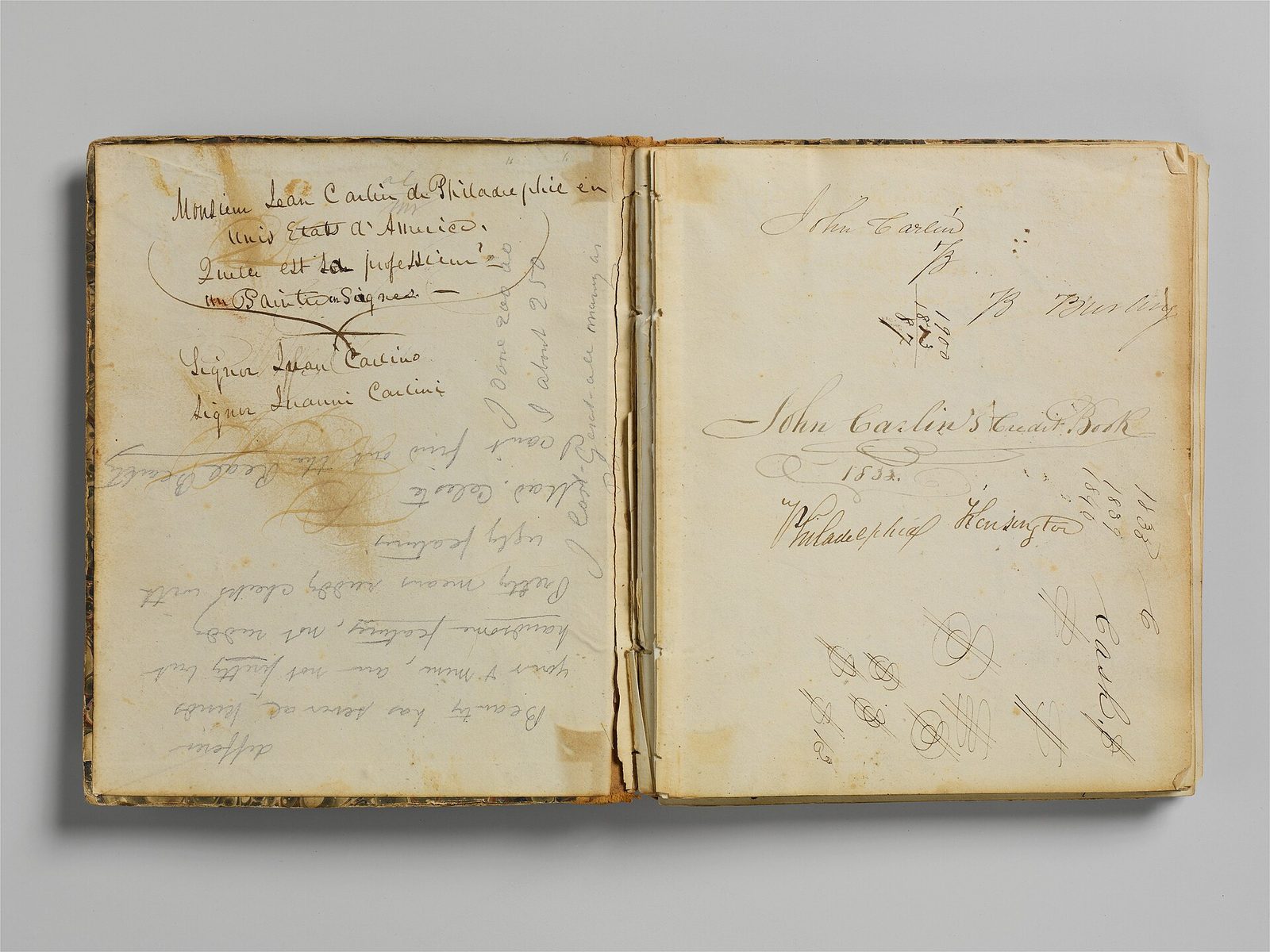 An old handwritten account book lying open on a gray background, its yellowed pages filled with ink signatures and entries.